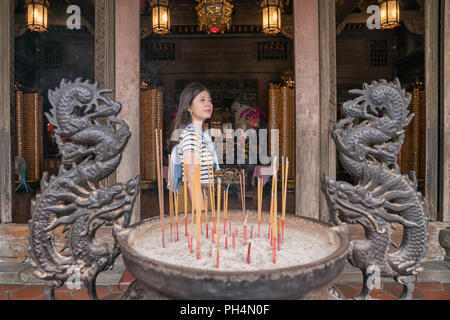 asian woman standing in the temple. Finishing the ritual for worshiping gods. Stock Photo