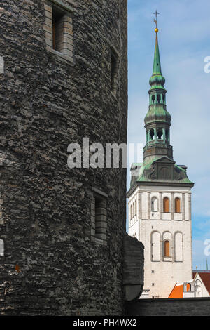 View of the tower and spire of St Nicholas Orthodox Church with a section of the medieval Kiek in de Kok tower in the foreground, Tallinn, Estonia. Stock Photo