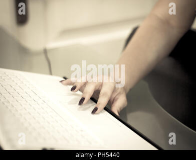 Womans hand on white computer keyboard. Copy space Stock Photo