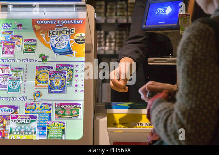 The  Millionnaire , scratch game, gambling in the FDJ (Française des Jeux  ).Scratch, coin, hands, fingers, close-up, 2011. Le millionnaire, jeu de  grattage, jeu d'argent de la FDJ( Française des Jeux ).