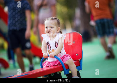 Little girl is riding on a swing Stock Photo