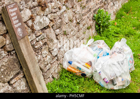 Please take your litter home sign with rubbish bags in the Brecon Beacons National Park Stock Photo