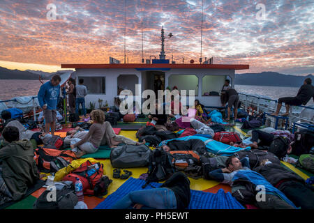 Sunrise on deck with sleeping tourists on the ferry from Wakai to Gorontalo, Sulawesi, Indonesia, Asia Stock Photo