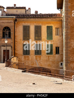 esplanade at the back of the Piti palace, from the Boboli gardens, in Florence, with its old walls in a worn light brown color and the blinds in green Stock Photo