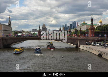 Moscow Kremlin and the Bolshoy Moskvoretsky Bridge over the Moskva River pictured from the Floating Bridge in Zaryadye Park in Moscow, Russia. Skyscrapers of the Moscow International Business Centre, also known as Moscow City, and the main building of the Ministry of Foreign Affairs of Russia, one of the seven Stalinist skyscrapers designed Soviet architects Vladimir Gelfreykh and Adolf Minkus. Stock Photo