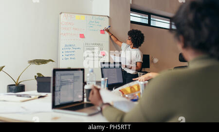 Team leader discussing and brainstorming new approaches and ideas with colleagues over new project. Business presentation at software development comp Stock Photo