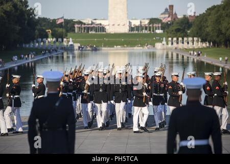 Marines with Alpha Company, Marine Barracks Washington D.C., march onto the parade deck during a Tuesday Sunset Parade at the Lincoln Memorial, Washington D.C., June 26, 2018. The guest of honor for the parade was the Honorable William McClellan Thornberry, Texas’ 13th Congressional District Congressman, and the hosting official was Lt. Gen. Steven R. Rudder, deputy commandant, aviation, headquarters Marine Corps. Stock Photo