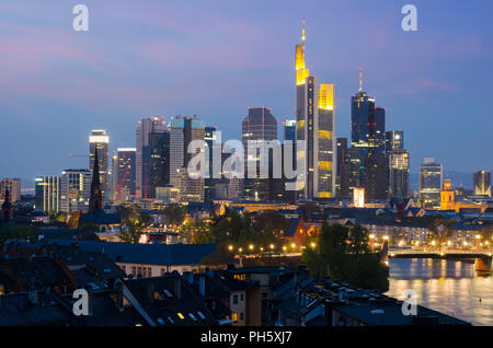 View of Frankfurt am Main skyline at dusk along Main river with cruise ship in Frankfurt, Germany Stock Photo