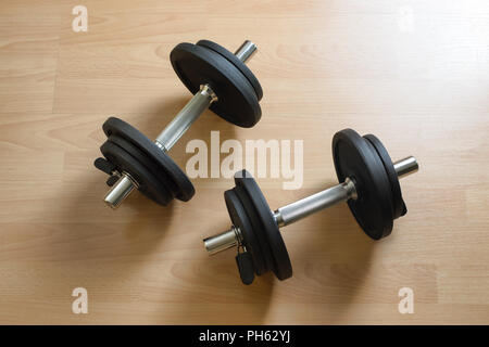 Weights dumbells on home wooden floor Stock Photo