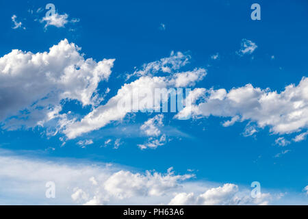 Puffy white cumulus clouds against a clear blue central Colorado sky; USA Stock Photo