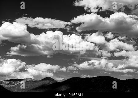 Black & white view of puffy white cumulus clouds against a clear blue central Colorado sky; USA Stock Photo