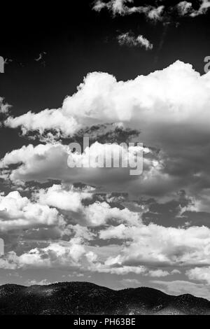 Black & white view of puffy white cumulus clouds against a clear blue central Colorado sky; USA Stock Photo