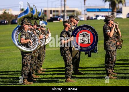 Marine Band San Diego, Marine Corps Recruit Depot, San Diego, Calif., performs during a change of command ceremony for Lt. Col. Christopher D. Siler, off-going commanding officer, Marine Wing Support Squadron 374-, and Lt. Col. Eric M. Beckmann, on-coming commanding officer, MWSS 374-, at Lance Cpl. Torrey L. Gray Field aboard the Marine Corps Air Ground Combat Center, Twentynine Palms, Calif., June 25, 2018. Changes of command ceremonies are a Marine Corps tradition that signifies the transition of unit leadership from one officer to another. Stock Photo