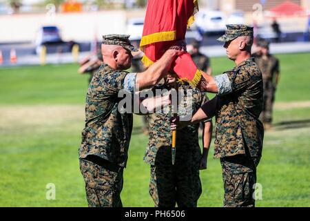 Lt. Col. Christopher D. Siler, off-going commanding officer, Marine Wing Support Squadron 374-, transfer the squadron colors to Lt. Col. Eric M. Beckmann, on-coming commanding officer, MWSS 374-, during a change of command ceremony at Lance Cpl. Torrey L. Gray Field aboard the Marine Corps Air Ground Combat Center, Twentynine Palms, Calif., June 25, 2018. Changes of command ceremonies are a Marine Corps tradition that signifies the transition of unit leadership from one officer to another. Stock Photo