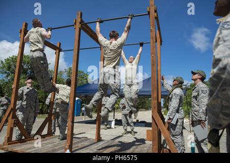 A team of competitors in the 2018 Advanced Combat Skills Assessment, performs pull-ups during a combat fitness test, 18 June 2018, on Andersen Air Force Base, Guam. The ACSA tested security forces teams from throughout the Pacific Air Forces on core tasks of base defense, to include landnav, tactics, mental and physical challenges, and weapons firing. Stock Photo