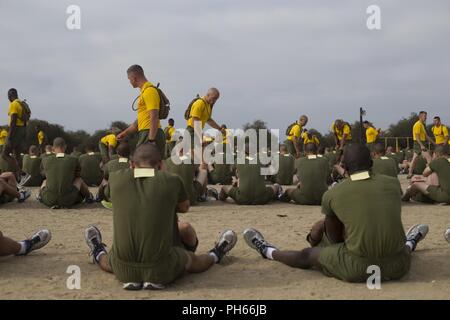 Drill instructors with Fox Company, 2nd Recruit Training Battalion, supervise recruits as they perform crunches during a physical fitness test at Marine Corps Recruit Depot San Diego, June 25. During this portion of the test, recruits must perform as many crunches as possible within two minutes. Annually, more than 17,000 males recruited from the Western Recruiting Region are trained at MCRD San Diego. Fox Company is scheduled to graduate Aug. 10. Stock Photo