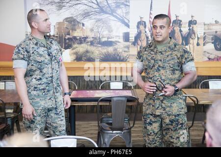 (Left) Outgoing 1st Sgt. Neil Roselli listens as his replacement, 1st Sgt. Enrique De Anda, presents Roselli with a going away gift representing his time at Marine Corps Logistics Base Barstow as Headquarters Company First Sergeant and senior NCOIC of the only remaining Mounted Color Guard in the Marine Corps, June 18. De Anda also commented on how unusual it was for the person he is replacing to still be on the job when he arrives to take over. Stock Photo