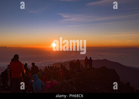 People on the summit of volcano Rinjani watching sunrise, Lombok, Indonesia Stock Photo