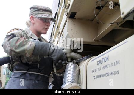 Pvt. Kayla Day, a petroleum supply specialist with Company A, 237th Brigade Support Battalion, provides fuel to a Light Medium Tactical Vehicle (LMTV) during annual training June 24 at the Camp Grayling Joint Maneuver Training Center in Grayling, Mich. (Ohio Army National Guard Stock Photo