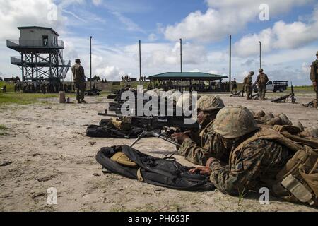 U.S. Marines with Fox Company, Marine Combat Training Battalion (MCT), School of Infantry-East, sight in on an a M240G Medium Machinegun during Table 3 and 4 marksmanship training, Camp Lejeune, N.C., June 27, 2018. MCT conducts standards-based common combat skills training of entry-level Marines in order to create riflemen for service throughout the Marine Corps. Stock Photo