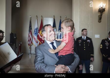 Gerald O’Keefe, Administrative Assistant to the Secretary of the Army holds his grandson in the Memorial Amphitheater Display Room at Arlington National Cemetery, Arlington, Virginia, June 29, 2018. Stock Photo