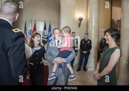 U.S. Army Maj. Gen. Michael Howard (left), commanding general, U.S. Army Military District of Washington; presents a certificate for laying a wreath at the Tomb of the Unknown Soldier to Gerald O’Keefe (center left, holding his grandson), Administrative Assistant to the Secretary of the Army; and O’Keefe’s wife (center right) as Katharine Kelley (right), superintendent, Arlington National Cemetery, looks on in the Memorial Amphitheater Display Room at Arlington National Cemetery, Arlington, Virginia, June 29, 2018. Stock Photo
