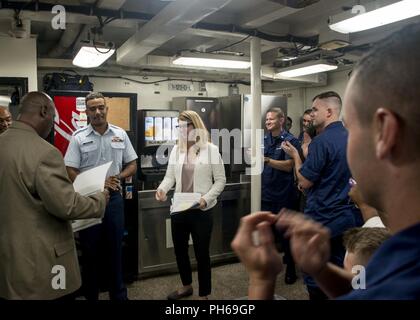 The crew of the Coast Guard Cutter Resolute, a 210-foot medium-endurance Reliance class cutter homeported in St. Petersburg, Florida, cheers on Seaman Kenwyn Berkeley after he takes the Oath of Allegiance to become a U.S. citizen Friday, June 29, 2018. Berkeley was required to take part in a series of tests and interviews administered by the U.S. Citizenship and Immigration Services as a part of the naturalization process. Stock Photo