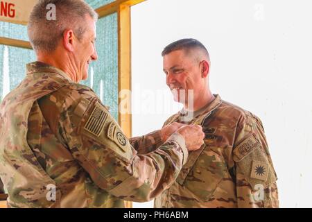KANDAHAR AIRFIELD, Afghanistan (June 30, 2018) -- U.S. Army General John W. Nicholson, the NATO-led Resolute Support commander, pins a Defense Superior Service Medal on U.S. Army Brig. Gen. John Lathrop, Train, Advise and Assist Command-South outgoing commander,during an awards ceremony, June 30, 2018, in Kandahar, Afghanistan. Lathrop, assigned to the 40th Infantry Division, California National Guard, relinquished authority of TAAC-South to U.S. Army Brig. Gen. Jeffrey Smiley, incoming commander. Stock Photo