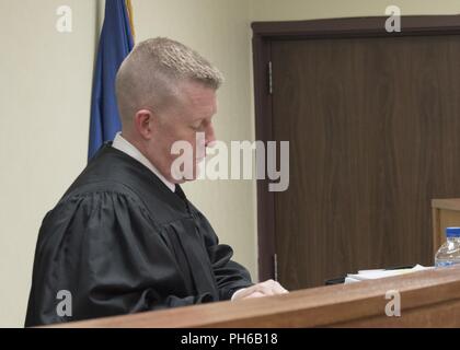 Lt. Col. Steven Neill, U.S. Army military judge, listens to the procedings in the courtroom during a mock trial June 29, 2018 at Kadena Air Base, Japan. The mock trial was a part of the Military Justice Symposium, in which members from all branches of the U.S. military and local Okinawan legal members converged on Kadena Air Base for a knowledge exchange. Stock Photo