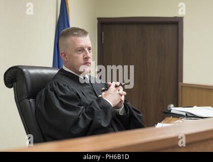 Lt. Col. Steven Neill, U.S. Army military judge, listens to the procedings in the courtroom during a mock trial June 29, 2018 at Kadena Air Base, Japan. The mock trial was a part of the Military Justice Symposium, in which members from all branches of the U.S. military and local Okinawan legal members converged on Kadena Air Base for a knowledge exchange. Stock Photo