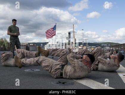 Poland (June 30, 2018) U.S. Marine Cpl. Joseph Schultz, left, from Cary, North Carolina, leads Marines during a physical training aboard the Harpers Ferry-class dock landing ship USS Oak Hill (LSD 51), in Gydnia, Poland, June 30, 2018. Oak Hill, home-ported in Virginia Beach, Virginia, is conducting naval operations in the U.S. 6th Fleet area of operations. Stock Photo