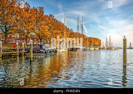 Enkhuizen, The Netherlands, October 26, 2015: Trees in autumn colors reflect in the Buitenhaven (Outer Harbour) Stock Photo