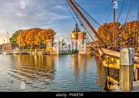 Enkhuizen, The Netherlands, October 26, 2015: historic saling yacht moored in the Buitenhaven (Outer Harbour) with Dromedaris Gate in the background Stock Photo