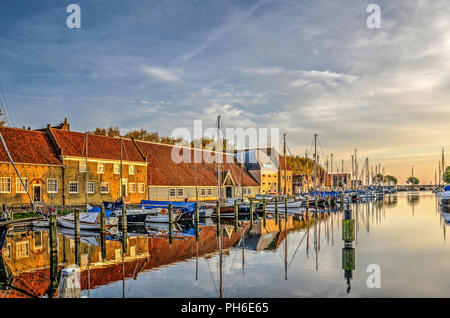 Enkhuizen, The Netherlands, October 26, 2015: historic warehouses and modern yachts reflect in the perfectly calm water of the Eastern Harbour Stock Photo