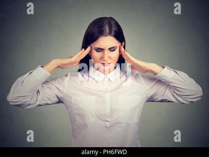 Woman holding fingers on temples trying to concentrate on decision making looking stressed Stock Photo