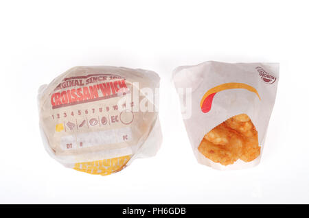 Burger King sausage, egg and cheese Croissan’wich and hash browns in wrappers on white background Stock Photo