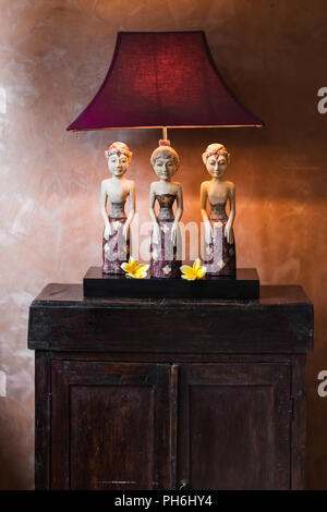 VIntage lamp on nightstand with tree balinese statuette Stock Photo