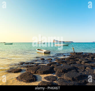 Boats in a sea at day time. Flat island on a background. Mauritius Stock Photo