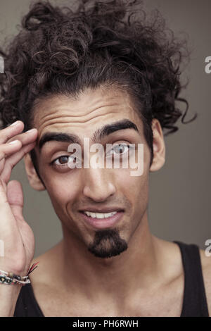 Curly-Haired Young Man Smiling at the Camera Stock Photo