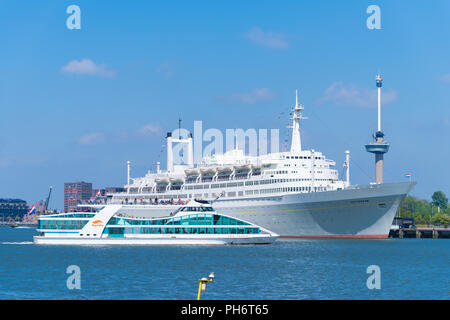 ROTTERDAM, NETHERLANDS - MAY 6, 2017: Tour boat in front of the SS Rotterdam, a former cruise ship of the Holland-America line Stock Photo