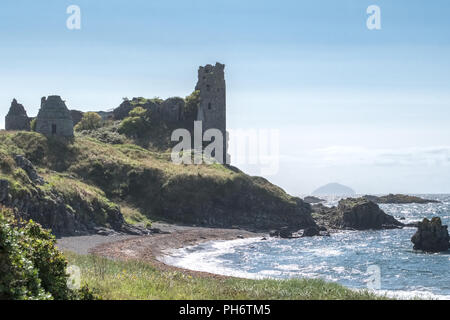 The ancient ruins of Castle Dunure with Ailsa Craig in the hazy distance taken on a warm  hazy sunny day and is a good image for Scotland's tourism. Stock Photo