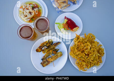 Two beers, white plates with different snacks, summer Stock Photo