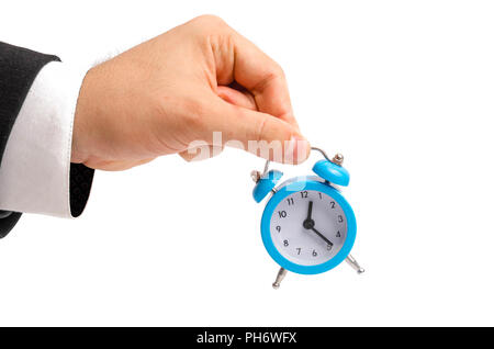 A businessman is holding an alarm clock. Watch in hand. The concept of hourly pay, time. Late for work. Full or incomplete rate. Overtime at work. Pen Stock Photo