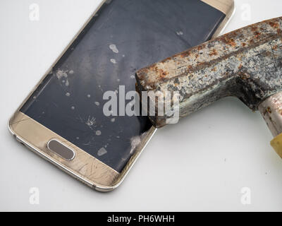 close-up of damaged smartphone display with hammer and white background Stock Photo