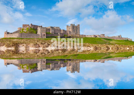 Bamburgh Castle, Northumberland, at high tide - Photoshop effect. Stock Photo