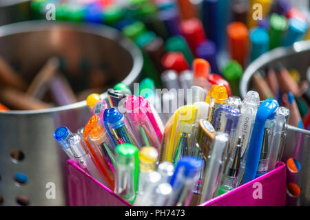 Close up image of pots of coloured pens and crayons in a school art classroom Stock Photo