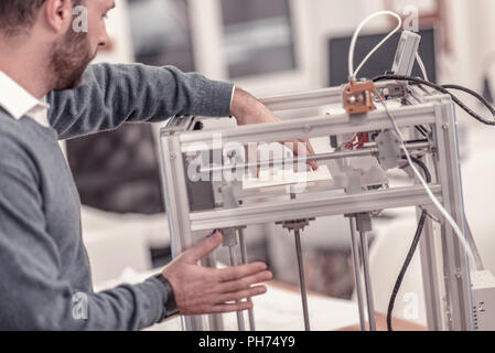 Ingenious designer working with 3D printer in design studio Stock Photo