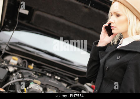 Young woman calling roadside assistance Stock Photo
