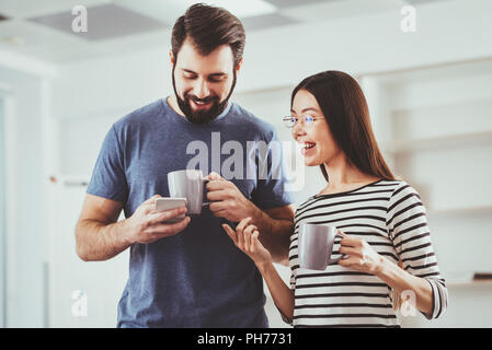 Nice pleasant man using his smartphone Stock Photo