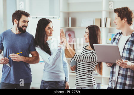 Positive young women giving high five to each other Stock Photo